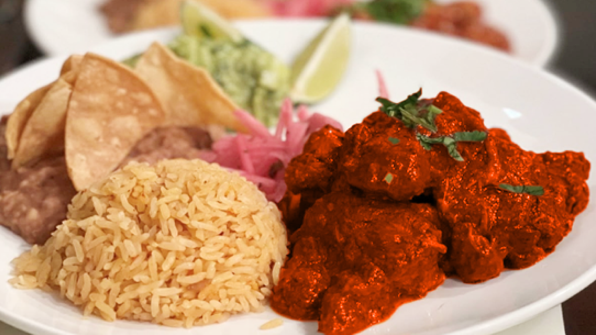 Anaya's Restaurant – plate of chicken in red chile sauce with rice, beans, guacamole and tortilla chips.