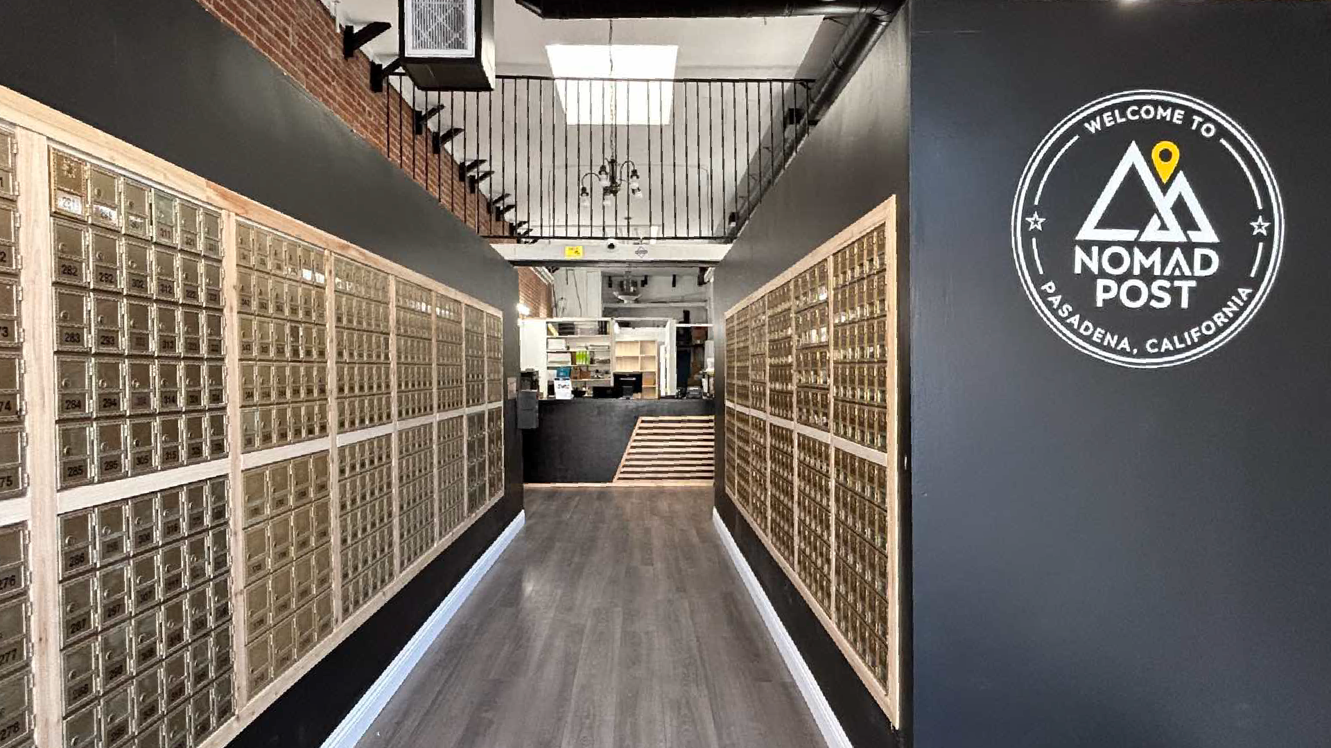 Nomad Post – hallway of private mailboxes with the Nomad Post Pasadena logo on the wall.
